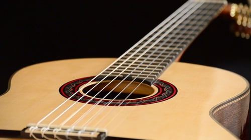 Classic Guitar Gyrating at Black Background