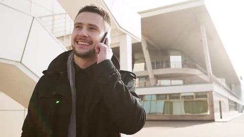 Young Adult Talking on Smartphone Outside Building