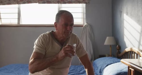 Senior Mann trinkt Wasser zu Hause