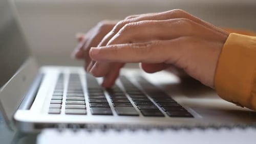Woman Typing on Laptop Keyboard in Office