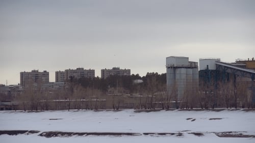View Of Plant With Pipes In The Winter. Homes And Factories