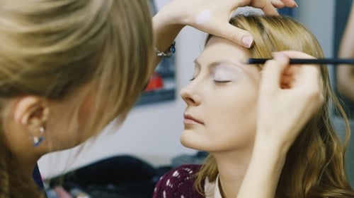 Makeup Artist Applying Makeup to Model's Eyebrows