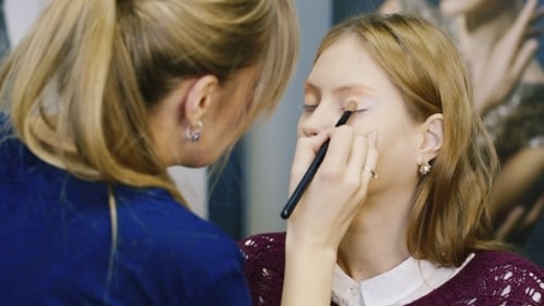 Makeup Artist Applying Eyeshadow to a Woman