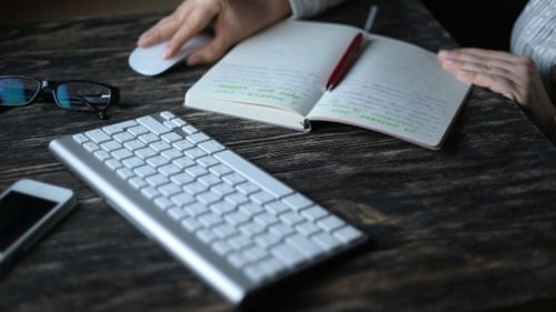 Woman Writing While Sitting In Her Office At Night