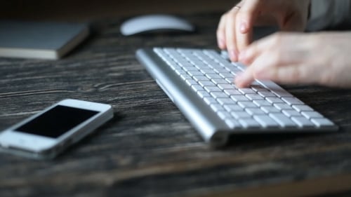 A Modern Workplace. Night Work. A Man Sits At a Computer And Types On The Keyboard.