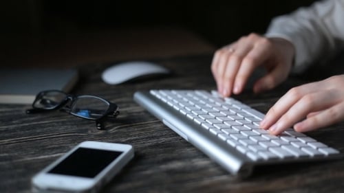 Night Work. A Man Sits At a Computer And Types On The Keyboard