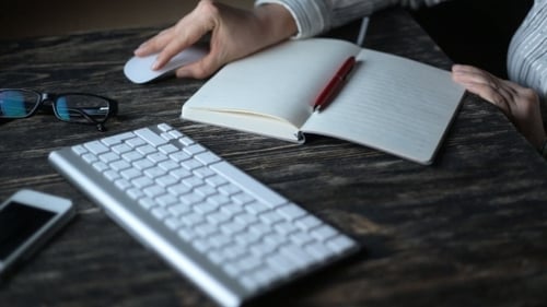 A Young Woman Writing While Sitting In Her Office At Night