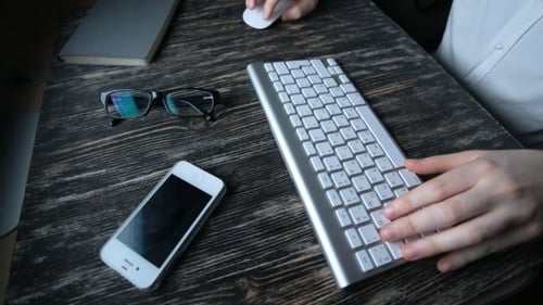 A Man Sits At a Computer And Types On The Keyboard.