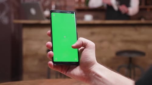 Man Scrolling on a Phone with Green Screen