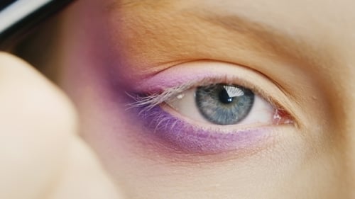 Make-up wird um das weibliche Auge aufgetragen