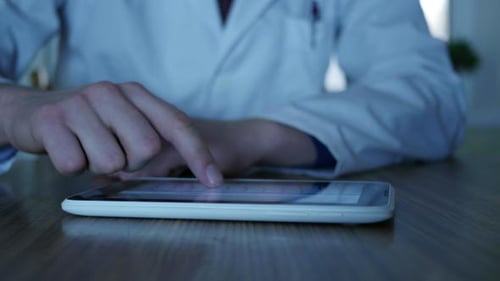Doctor Typing Text On Tablet