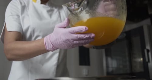 Chef Pouring Liquid into Pot in Kitchen