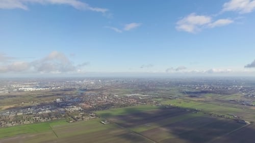 The Airplane Is Flying Above The City And Clouds