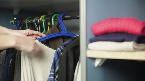 Selecting Plaid Shirt from Closet Clothes Hangers