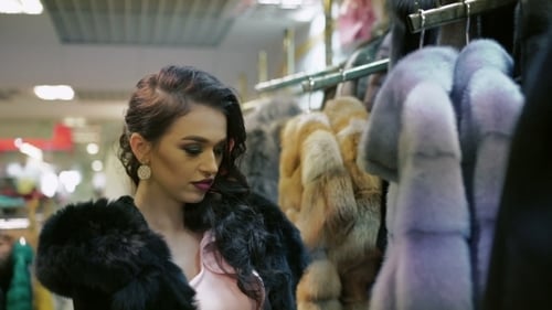 Rich Lady Choosing Fur Coat In The Shop