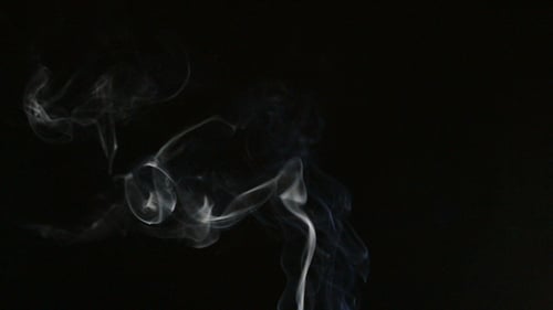 Rising Smoke: White Vapor Against Black Background