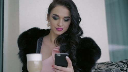Glamorous Lady Drinking Latte Seductively, Using Phone In Cafe
