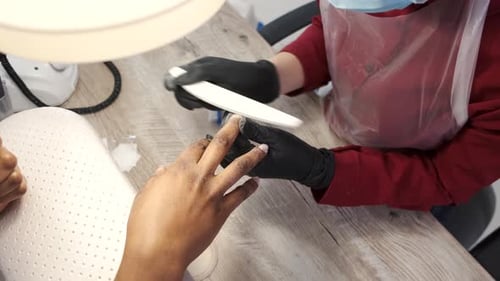 Manicurist Filing Nails for Beauty Treatment