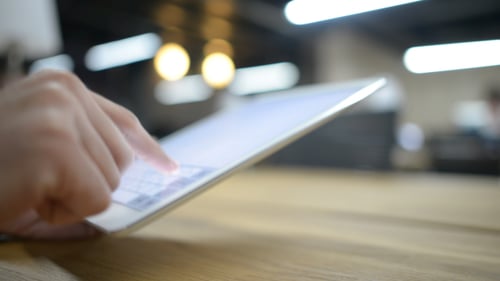Woman Typing on Tablet Device in Office Setting