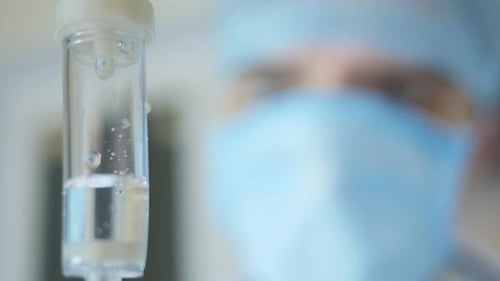 Intravenous Drip with Medical Professional in Background