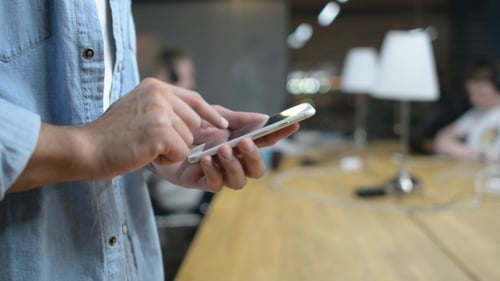 Man Using Mobile Phone in Modern Office Setting
