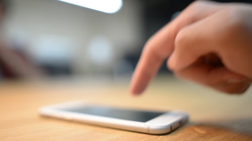 Finger Tapping Mobile Phone Screen on Table