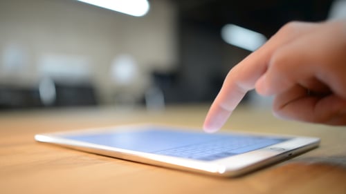 Hand Typing on Tablet in Bright Office Setting