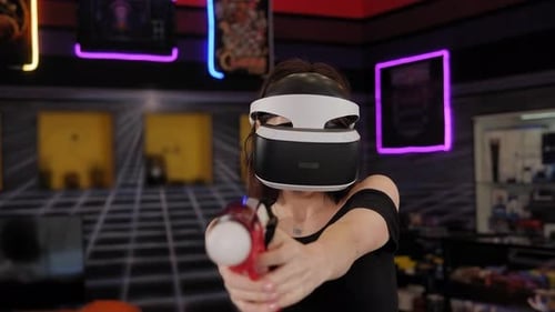 A Woman Use a Virtual Reality Headset with Glasses and Hand Motion Controllers