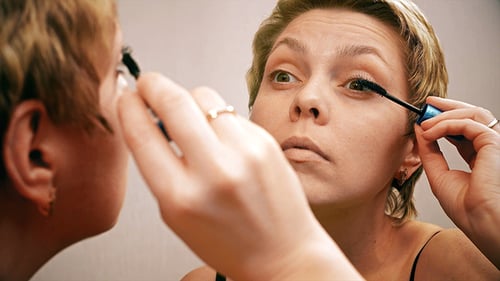 Woman Applying Mascara in Mirror Close Up