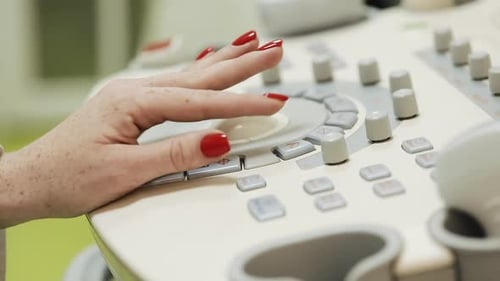 Hand Using Medical Ultrasound Equipment Controls