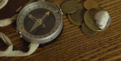 Vintage Compass, Coins, and Stone on Wooden Surface