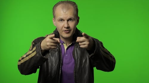 Hübscher Positive Rocker Man in brauner Jeansjacke zeigt mit dem Finger auf die Kamera Chroma-Schlüssel