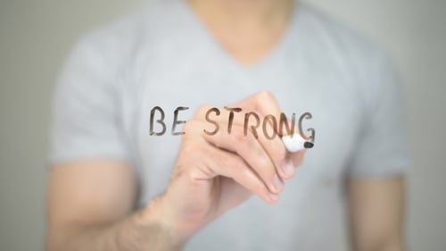 Man Writes "Be Strong" on Transparent Surface