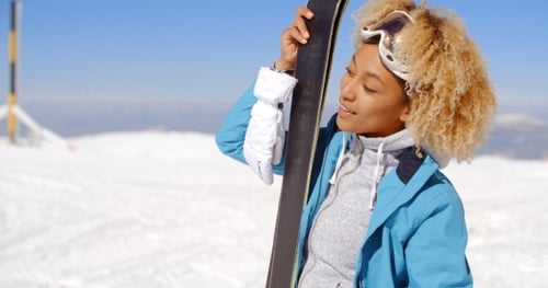 Woman Skier Smiling on Snowy Mountain Top