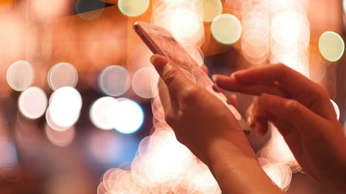 Woman Using Smartphone at Night in the City