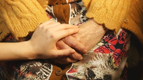 Eine junge Hand, die ein altes Paar Hände tröstet