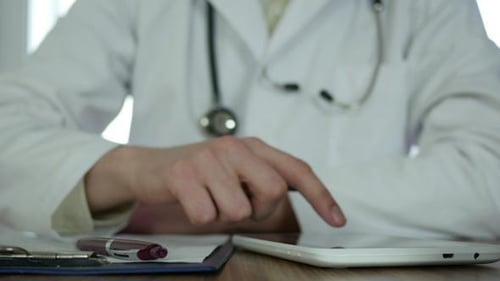 Médecin écrivant une prescription et tapant des SMS