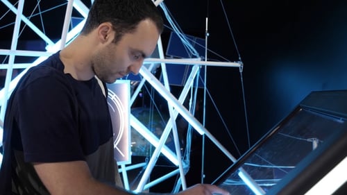 Man Using Futuristic Touchscreen in Tech Exhibit