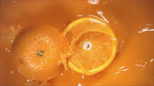 Orange Fruit Falling on Juice with Splash and Divided in Half
