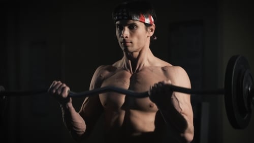 Portrait Of a Muscular Man Workout With Barbell At Gym.
