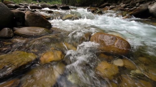 A River Flows Over Rocks In This Beautiful Scene In The Mountains