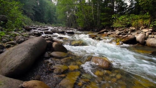 A River Flows Over Rocks In This Beautiful Scene In The Mountains