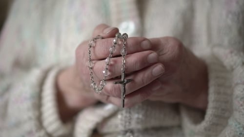 Person Holding Religious Rosary Beads in Hands
