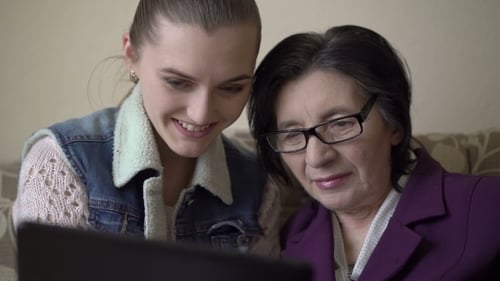 Grandmother and Granddaughter Using Tablet Together at Home