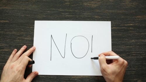 Man Hand Writing No With Black Marker On White Paper On Black Wood Table