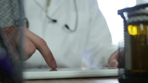 Doctor Uses Tablet in Modern Medical Office