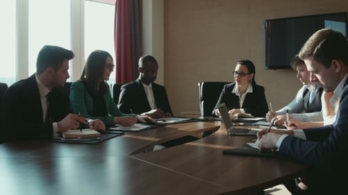 Eine Gruppe von Geschäftsleuten am Tisch spricht