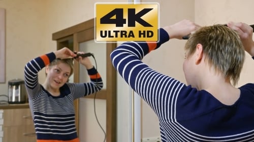 Woman Styling Her Short Hair With Curling Iron