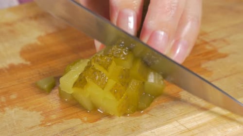 Cutting Diced Pickles on a Wooden Cutting Board
