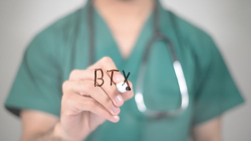 Doctor Writing BTX on Glass in Hospital